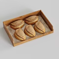 Five Freshly Baked Golden Brown Pastries in Wooden Tray on Light Background