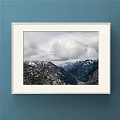 White Framed Landscape Painting With Snow Capped Peaks And Cloudy Sky