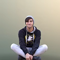 Man Sitting On The Ground Wearing Black Hoodie With Design Gray Beanie And White Pants