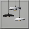 Modern Black And White Circular Pendant Lights With Metallic Accents In Illuminated Indoor Space