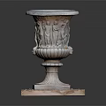 Small Grass Plants In Carved Stone Planter On Square Base With Pebbles