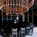 Modern Restaurant Interior With Round Chandelier Black Bar Counter And White Stools