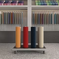 Colorful Fabric Rolls Display On Cart With Shelves In Showroom Interior