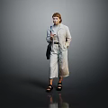 Woman In Light Gray Jumpsuit With Belt Holding Black Handbag Standing Against Dark Background