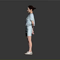 Woman in light blue short sleeve suit dress standing on gray background wearing white shoes
