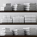 Soft Stacked Grey And White Towels With Striped Accents On Wooden Surface