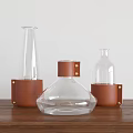 Modern Ceramic Vessels With Transparent Design And Brown Leather Wraps On Wooden Table