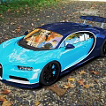 Shiny Blue Bugatti Sports Car With Sleek Design Parked On Gravel Ground With Fallen Leaves