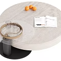 Round Light Gray Stone Coffee Table With Black Base Oranges Open Magazine And Glass Cups