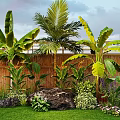 Lush Tropical Garden With Banana Plants Palm Tree Bamboo Fence Green Grass And Colorful Flowers