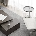Wooden Coffee Table With Open Book And Glass Cup Near White Chair On Rug