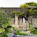 Garden Ornamental Scene With Rock Formations White Statue Bamboo Plants Stone Lanterns And Green Foliage