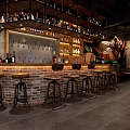 Industrial Style Bar Interior With Brick Counter Wine Bottles And Wooden Stools