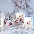 White Bathroom Essentials With Red Floral Patterns Including Soap Dispenser Toothbrush Holder And Tissue Box