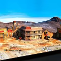 Wooden Residential Buildings with Red Signs in Desert Mountain Area and Blue Sky