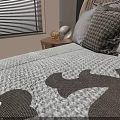Modern Double Bed With Textured Headboard Multiple Pillows Patterned Quilt And Wooden Chair