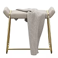 Modern Upholstered Stool With Light Gray Fabric Gold Metal Legs And Gray Blanket Draped