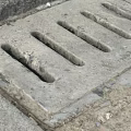 Gray Stone Pavement With Outdoor Drainage Grate And Urban Street Design
