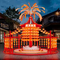 Red Art Installation with Firework Inspired Top and Hanging Orange Lanterns Near Traditional Buildings