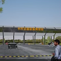 Entrance Gate of Super Racing Stadium with Cars and People in Outdoor Area