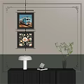 Abstract Paintings With Teal Truck And Floral Designs Hanging On Interior Wall With Table Lamp
