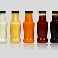 Colorful Condiment Bottles With Black Caps For Sauces On Gray Background