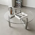 Modern Round Glass Coffee Table With Stainless Steel Legs Silver Pitcher Mugs And VOGUE Magazine