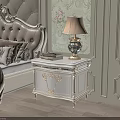 Ornate White Nightstand With Table Lamp And Books In Classic Bedroom With Floral Wallpaper
