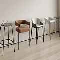 Various Design Bar Stools Arranged Against Light Colored Wall On Wooden Floor