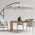 Outdoor Table and Chairs Set Wooden Top White Woven Chairs Umbrella Plant and Bowls