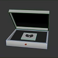 Opened Shiny Metallic Box Containing Square Item on Dark Background