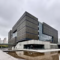 Modern Museum Building With Glass Curtain Wall And Water Reflection In Urban Area
