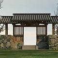 Traditional Entrance Gate With Tile Roof Stone Walls And Surrounding Trees In Grassland