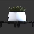White Planter With Eye Patterns And Spider Like Legs Holding Succulent Plant
