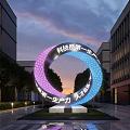 Ring Shaped Landscape Sculpture With Purple Blue Gradient Modern Buildings Evening Sky And Surrounding Trees