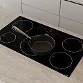 Modern Kitchen Black Induction Cooktop With Pan On Light Countertop And White Cabinets