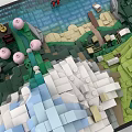 Building Blocks Model of Mountain Waterfall with Green Grass Pink Flowers and Small Boat