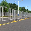 Municipal Road With Metal Fence Yellow Bases And Streetlights Along Trees
