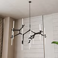 Modern Black Metal Chandelier With Branch Like Arms And White Tubes In Interior