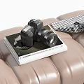 Modern Digital Camera Placed On Photography Book Over Leather Surface With Checkered Scarf