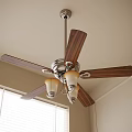 Ceiling Fan With Light Featuring Wooden Blades And Glass Shades In Room With Window