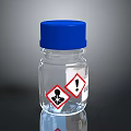 Transparent Glass Bottle With Blue Cap And Warning Hazard Symbols For Household Use