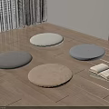 Round Gray and Brown Cushions on Wooden Floor with Stack of Books