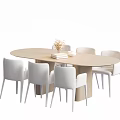 Light Colored Oval Dining Table And Six White Chairs Set With Vase Flowers And Books