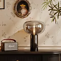 Glass Table Lamp with Black Base and Vintage Radio on Floral Wallpaper Background