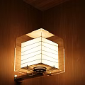 Modern Hexagonal Wall Lamp with Striped White Shade on Wooden Wall Emitting Warm Glow