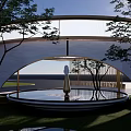Modern Waterside Landscape With Circular Pavilion Reflective Pool Curved Pathway And Lush Greenery
