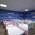 Colorful Kindergarten Room With Blue Green Walls Pink White Cribs Bookshelf TV And Tables