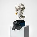 Decorative Ornament Set With White Sculpted Head Blue Box Black Ribbon On White Cube Base