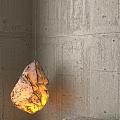 Illuminated Stone Shaped Decorative Lamp In Modern Living Room With Concrete Wall And Sofa